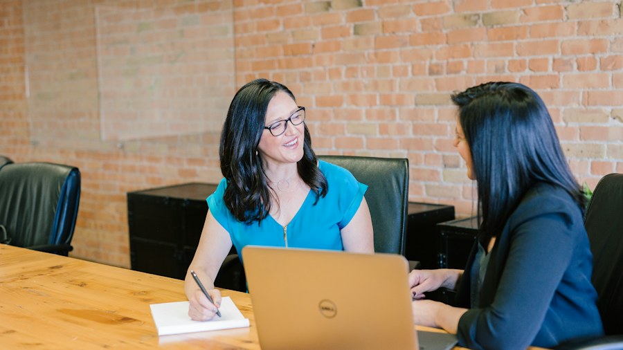 Two colleagues in a focused workplace conversation