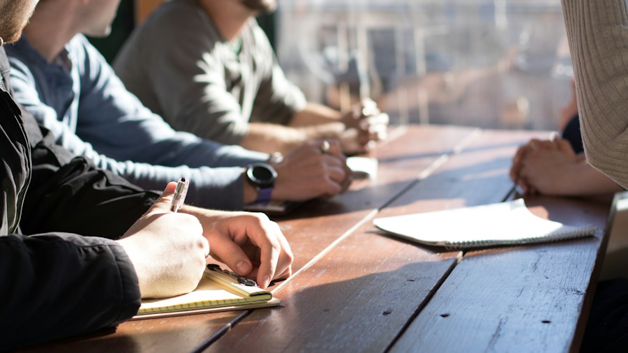 People sharing notes around a meeting table