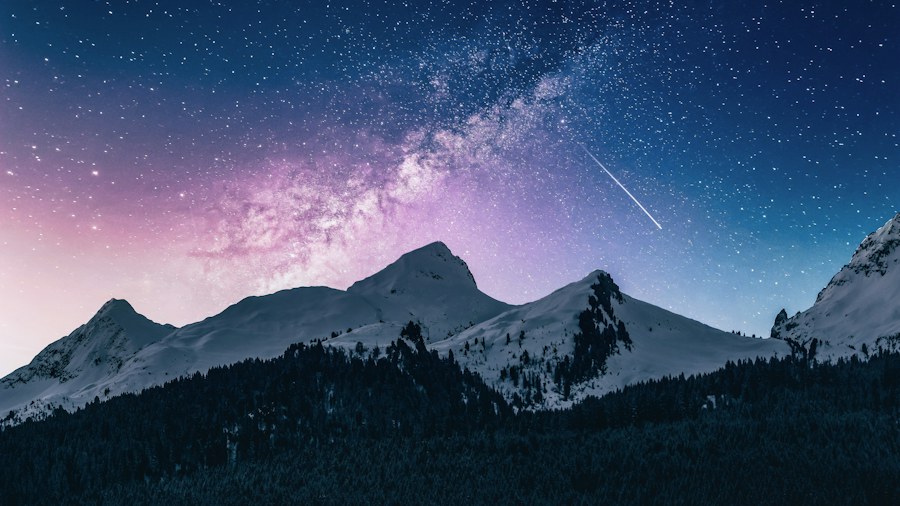 A star-filled night sky above distant mountains