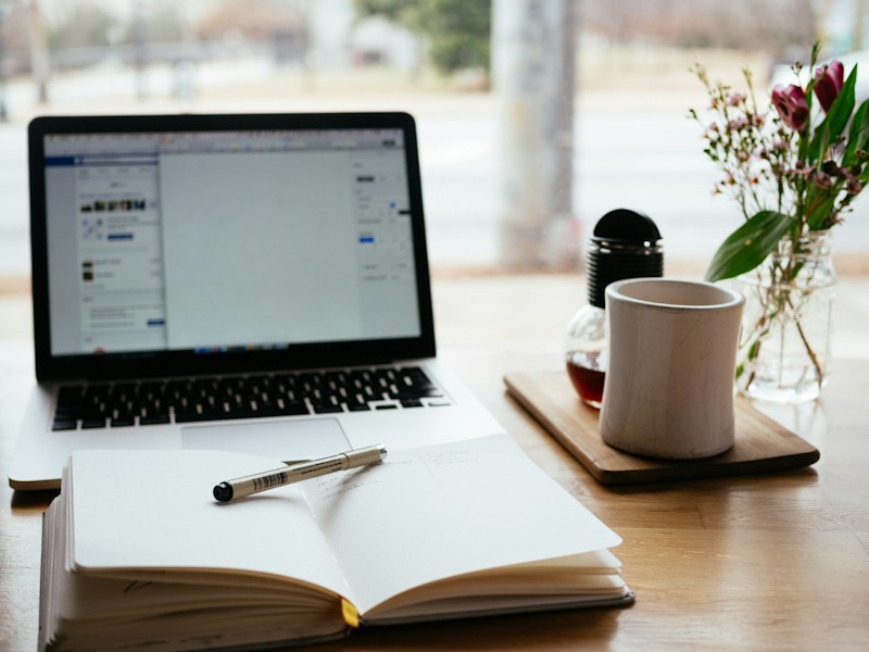 A laptop and open notebook on a study desk